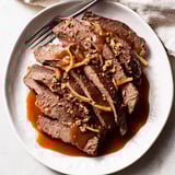 Einfache Sauerbraten-Rezeptfoto mit zarter Rinderbraten über knusprigem Gemüse.  